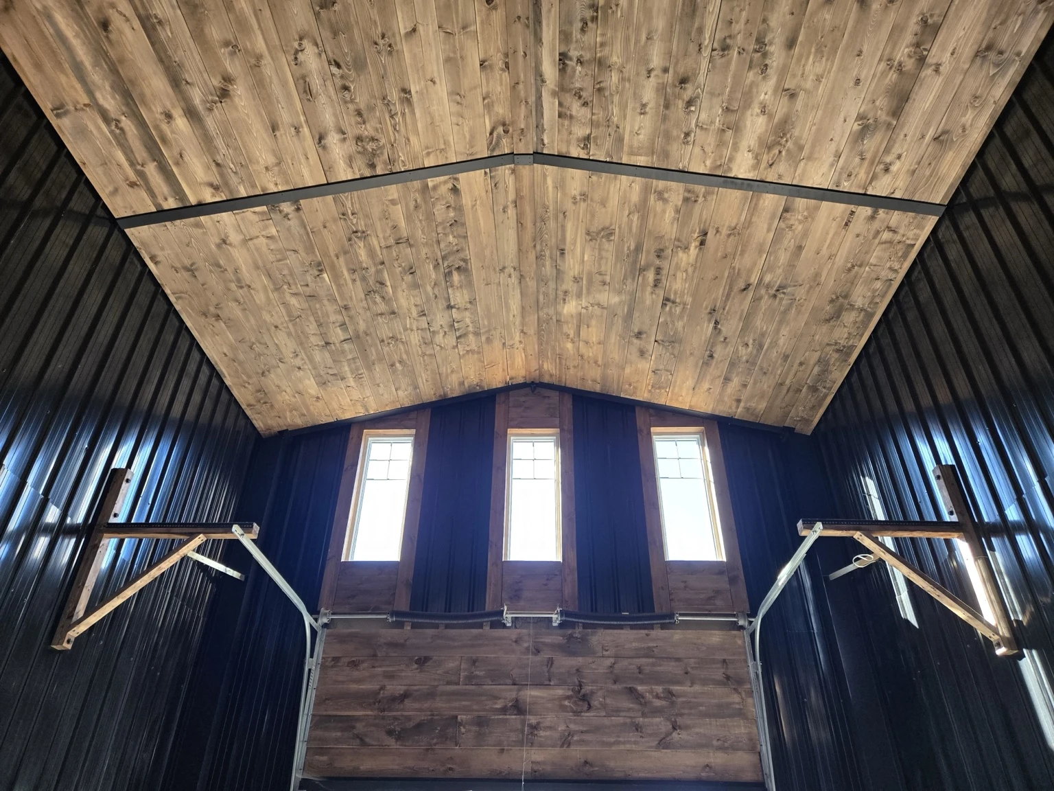 Clear-span cathedral ceiling with warm wood finish and exposed steel beam
