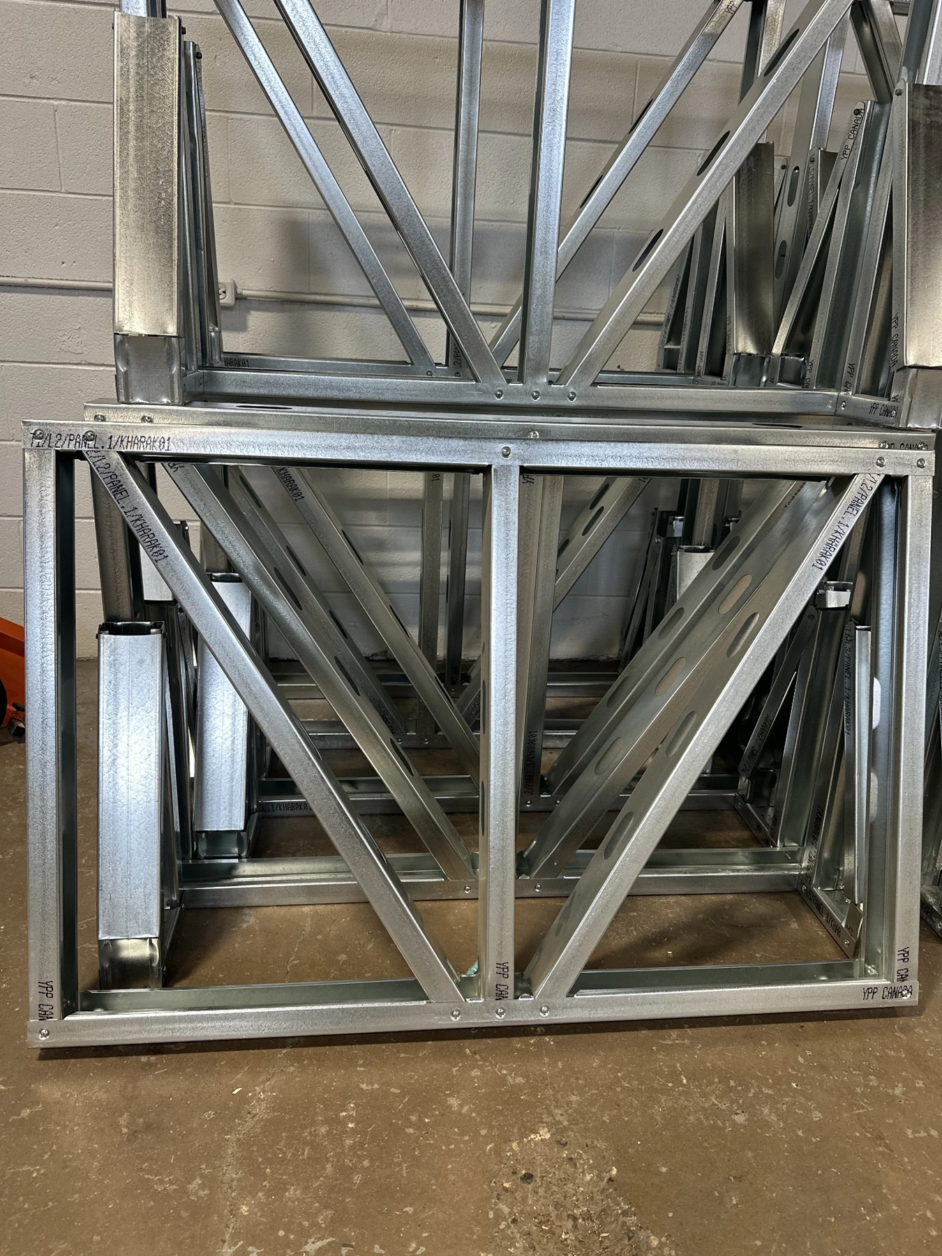 Factory-preassembled cold-formed steel wall panels stacked for assembly