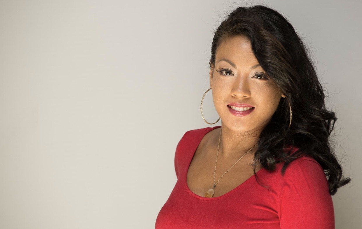Criscilla de Vera smiling in a red top