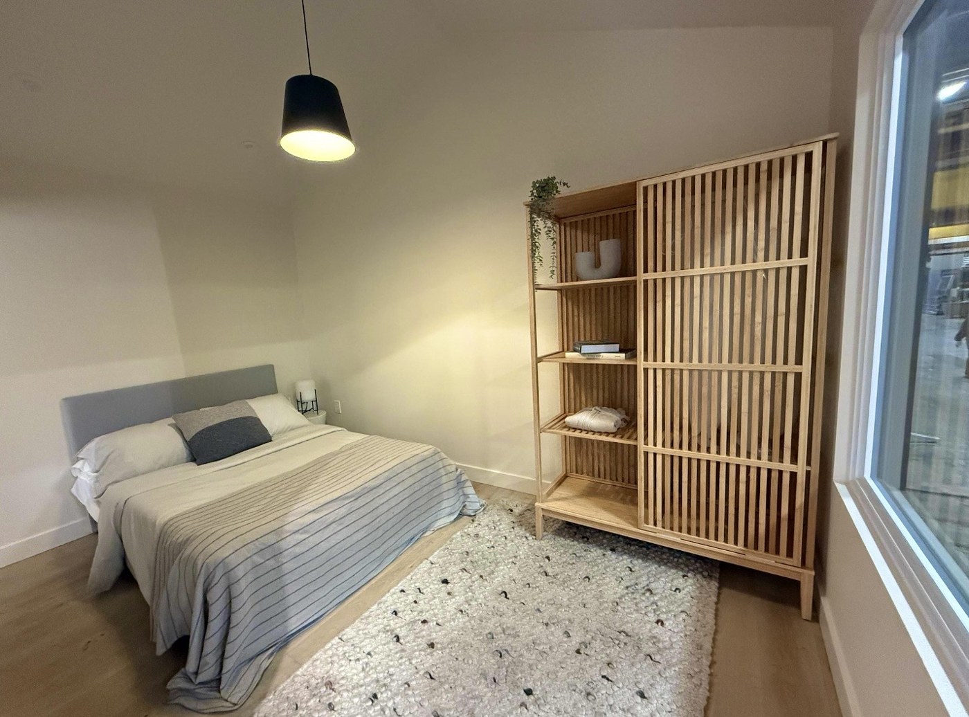 Finished compact bedroom with timber storage and a large window